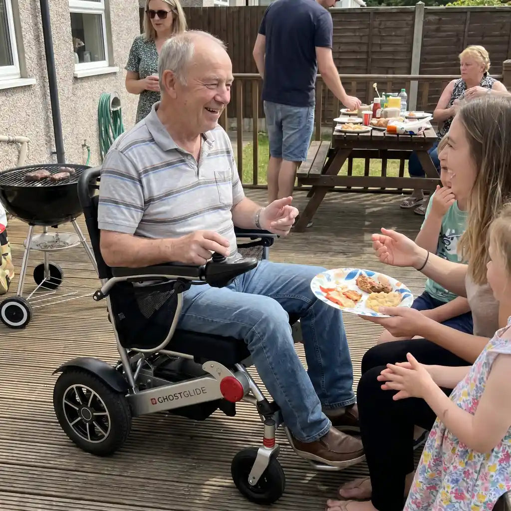 Senior man enjoying a family cookout in the Ghost Glide power chair